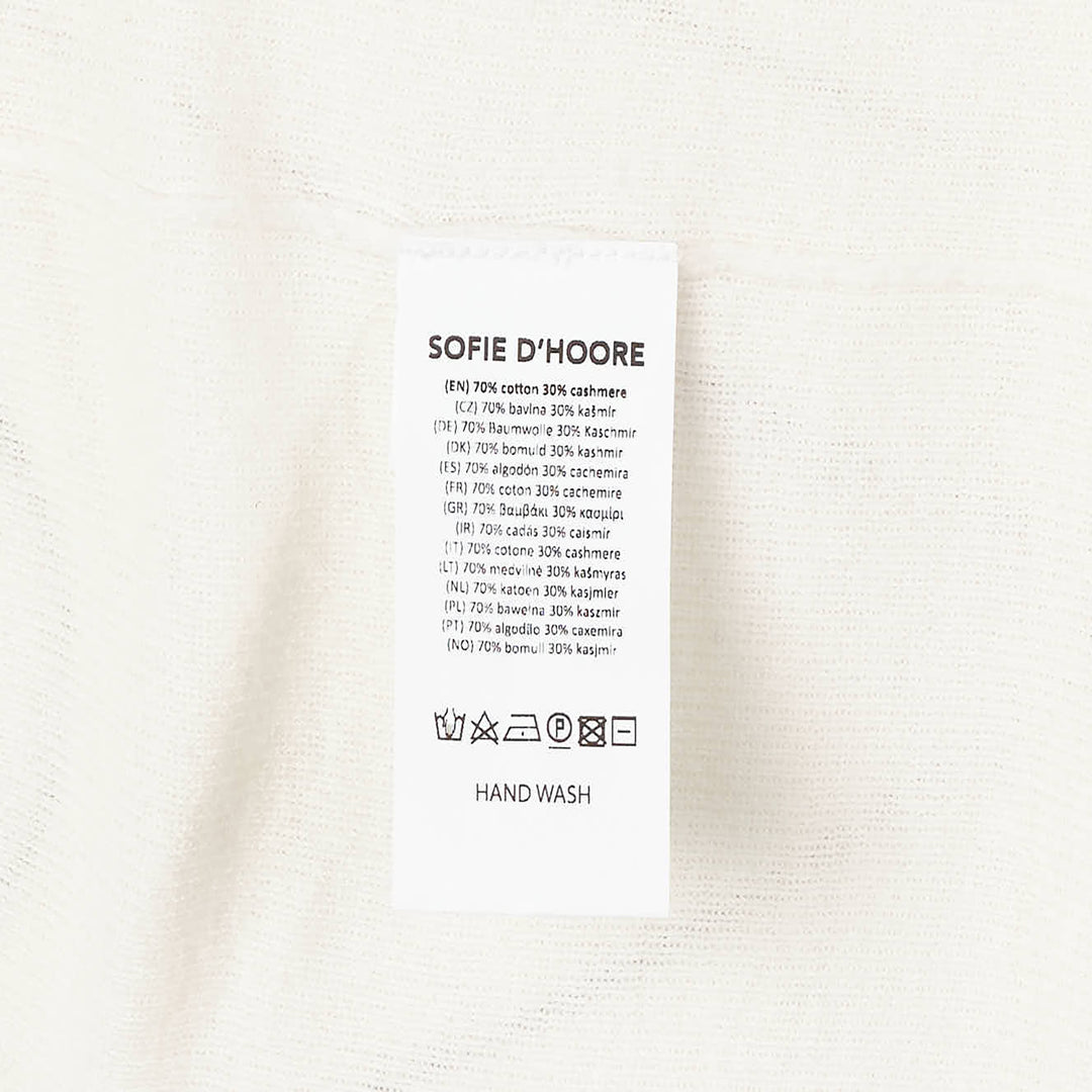 Sofie D'Hoore long sleeve turtleneck sweater in ivory fine-gauge knit with wide ribbed cuffs and foldover collar, displayed flat on a white background