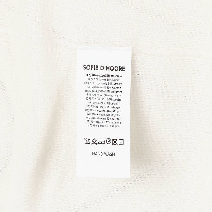 Sofie D'Hoore long sleeve turtleneck sweater in ivory fine-gauge knit with wide ribbed cuffs and foldover collar, displayed flat on a white background