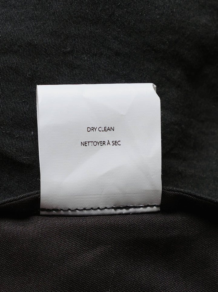 Lauren Manoogian black pleated taper trousers with a high waist and curved leg, shown from the front - view 3