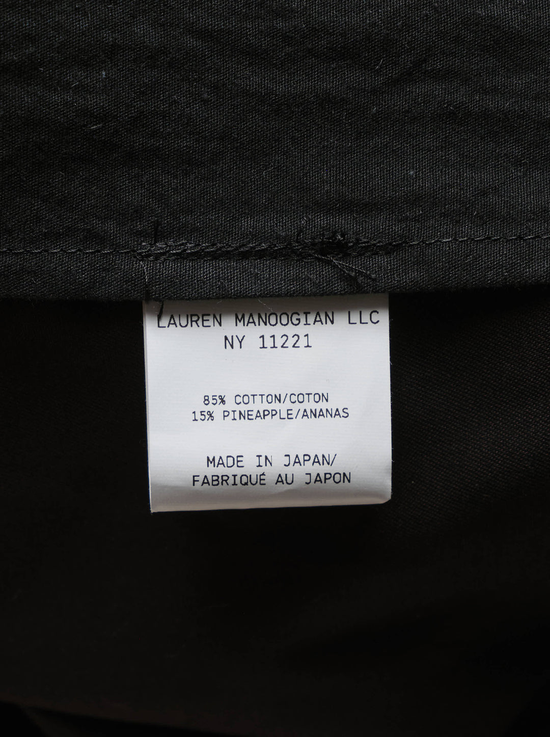 Lauren Manoogian black pleated taper trousers with a high waist and curved leg, shown from the front - view 4