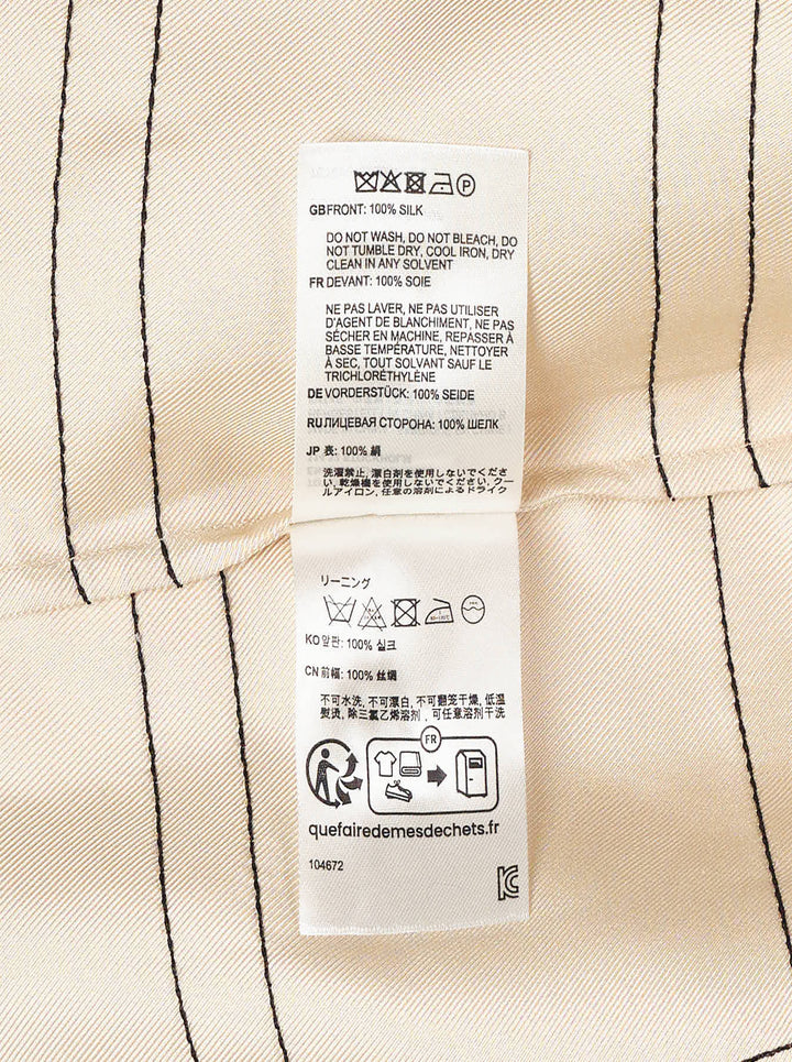 Totême Monogram Silk Pyjama Pants in champagne beige, featuring an all-over geometric monogram outline print, wide-leg silhouette, and elasticated waistband, displayed flat on a white background - view 3