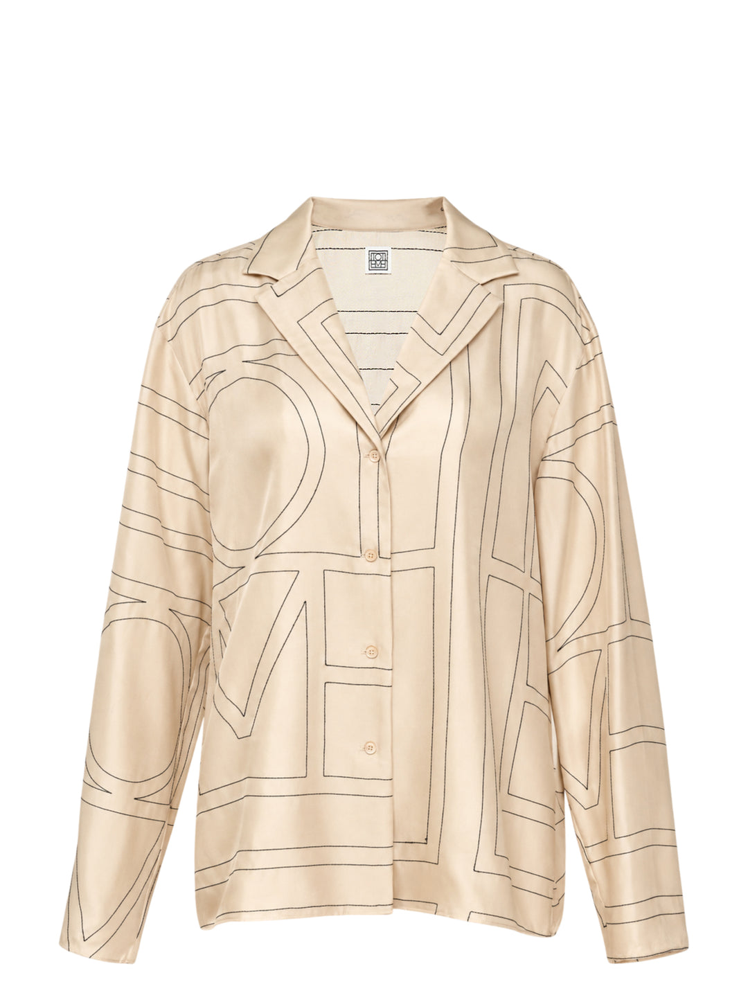 Totême Monogram Silk Pyjama Top in cream with dark outlined oversized logo lettering, notched lapel collar, button-through front, and long sleeves