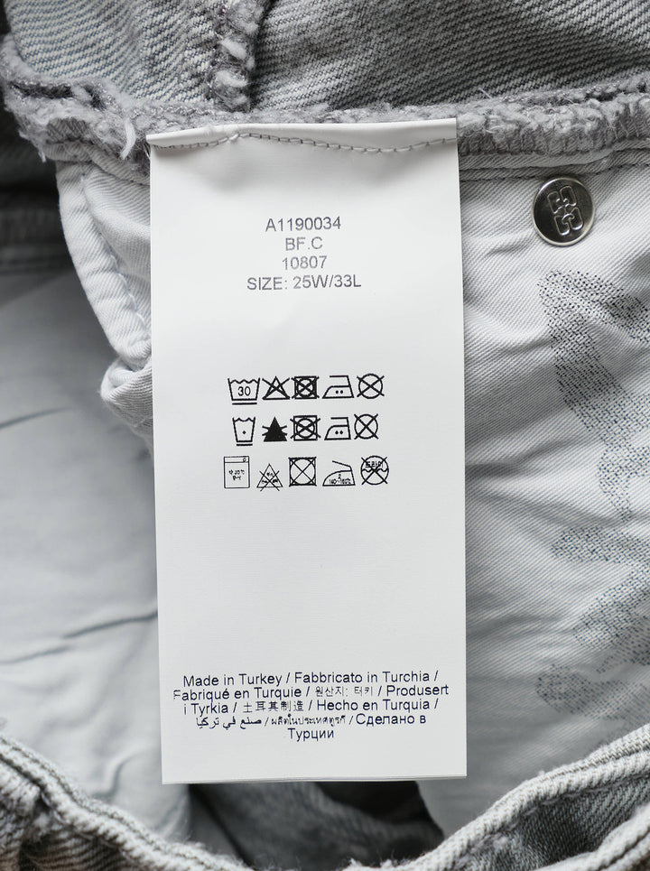 Ganni Rigid Denim Corset Jeans in light grey, featuring a high-rise waist, ruched corset seaming at the hip, and a wide balloon-leg silhouette tapering to small hem vents — front view on white background - view 3
