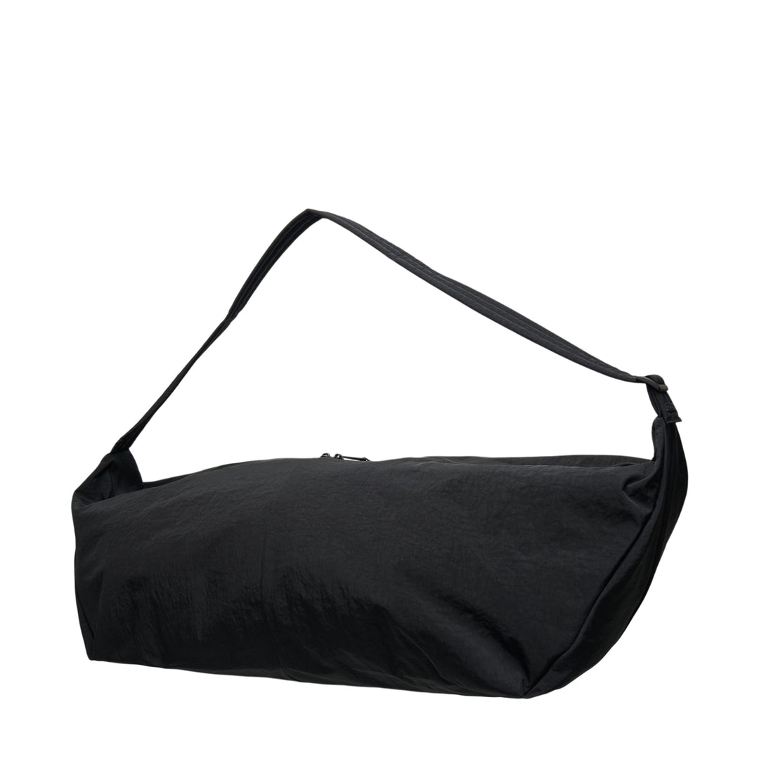 Fear of God ESSENTIALS x Eastpak Shell Bag Large in black, front view showing oversized body, wide shoulder strap, central zip closure, and co-branded woven label - view 2