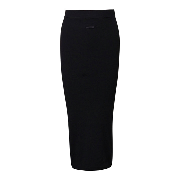 Fear of God Essentials black rib knit long midi skirt with wide elasticated waistband and tonal rubber logo tab, flat lay on white background