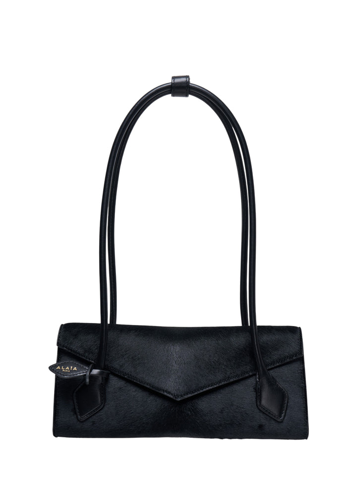 Alaïa Teckel Flap Small bag in black haircalf with sculptural double-looped handle and envelope flap closure, front view