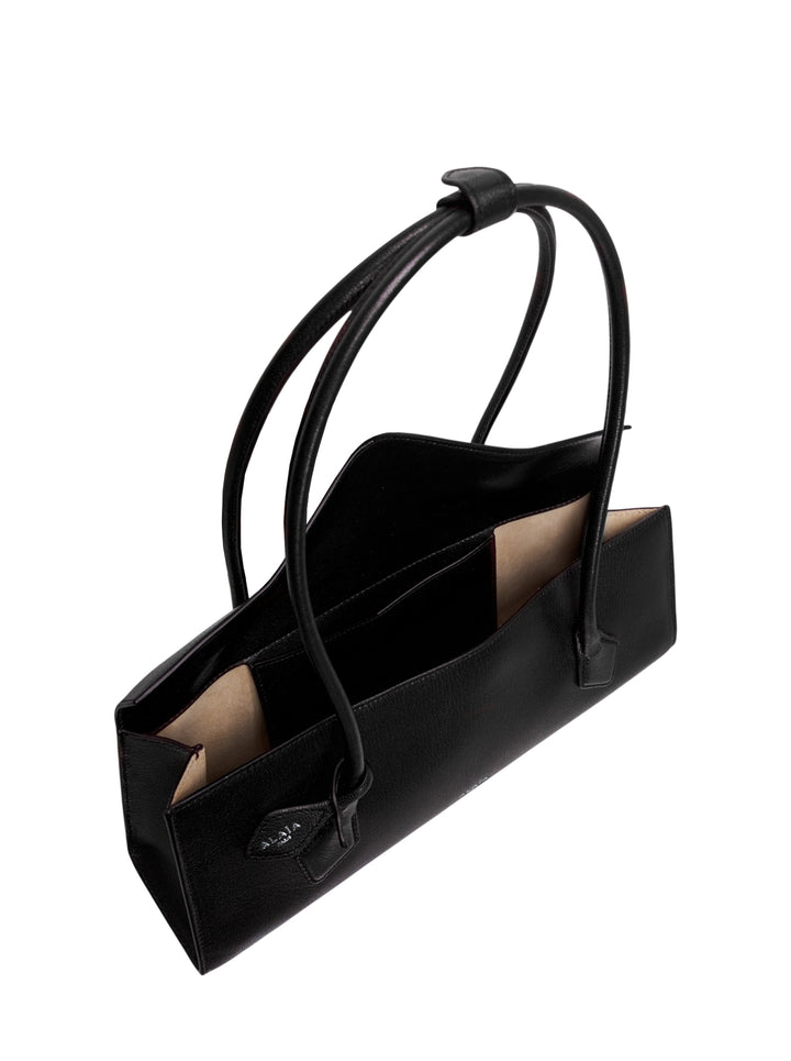 Alaïa Teckel Flap Medium shoulder bag in black shiny goatskin with elongated silhouette, V-point envelope flap closure, and twin handles fastened with a leather ring - view 3