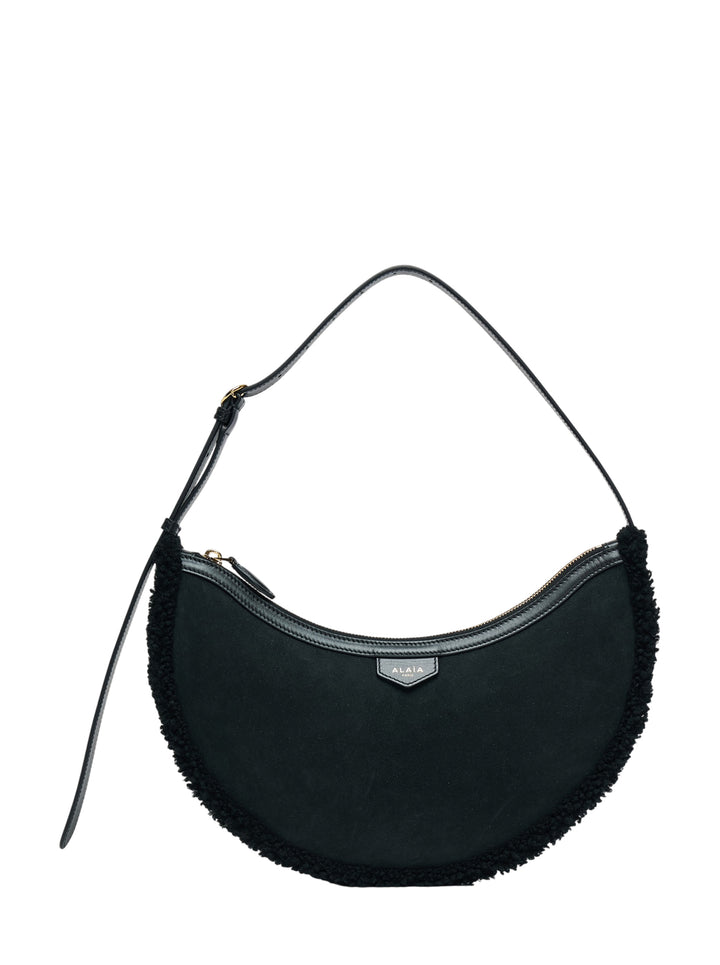 Alaïa Demi Lune black suede crescent shoulder bag with merino shearling trim and slim adjustable leather strap