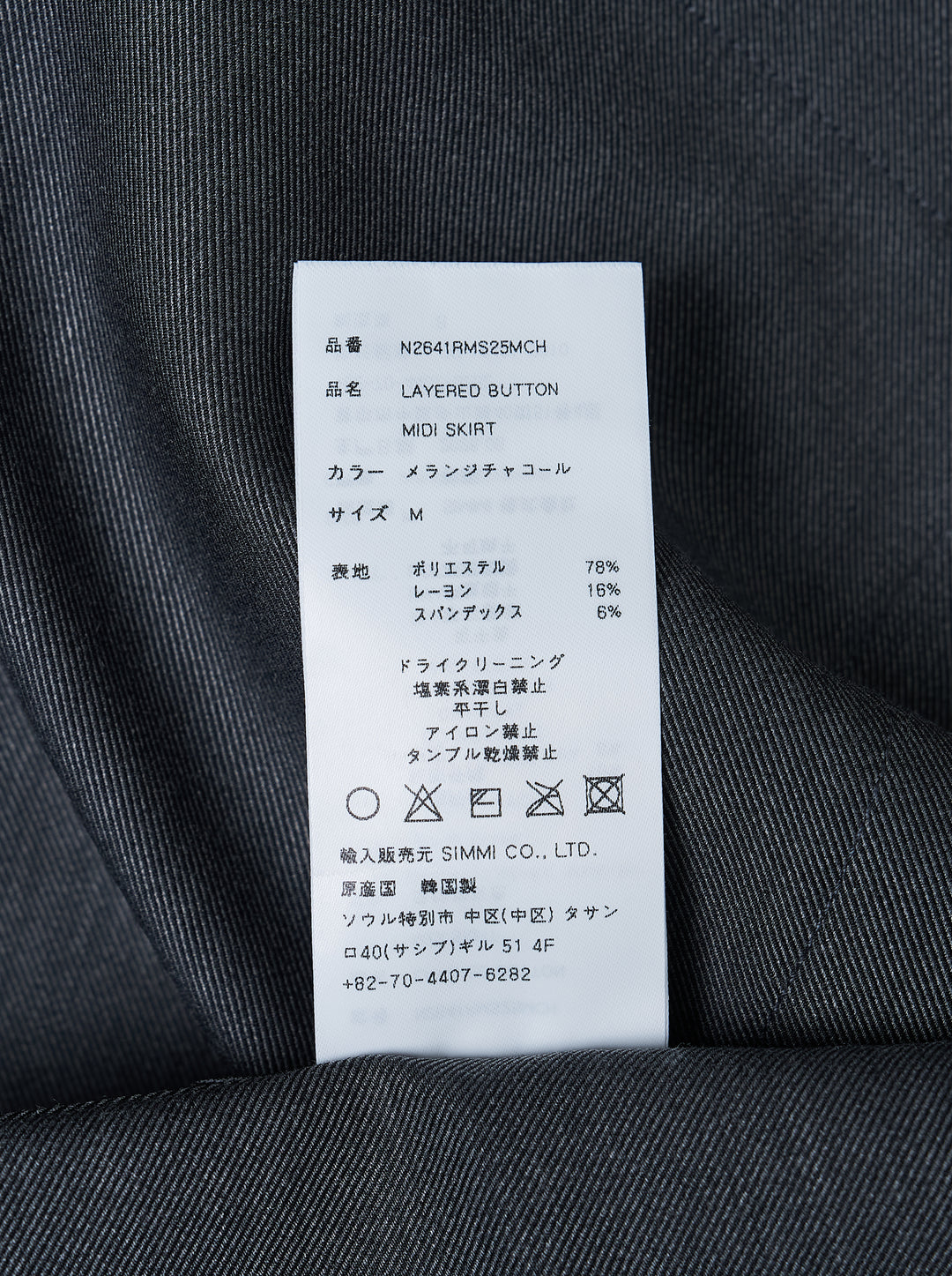 Nache charcoal grey A-line midi skirt with rows of dark buttons along both sides and buttoned waistband tabs - view 3