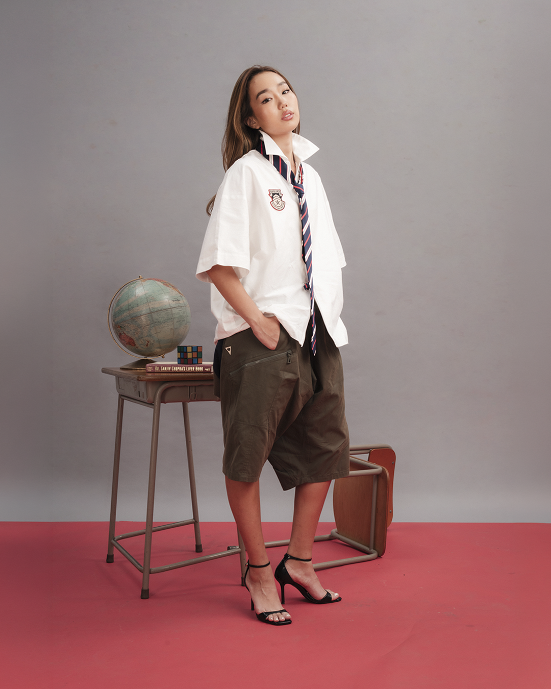 Blackjack Slacker Shirt in white, displayed flat — an oversized short-sleeve shirt with a centre-front zip, spread collar, and an embroidered collegiate crest badge on the chest