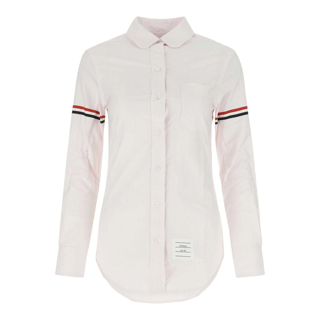Thom Browne classic long sleeve light blue pinstripe shirt with tricolor grosgrain ribbon armbands, front view on white background