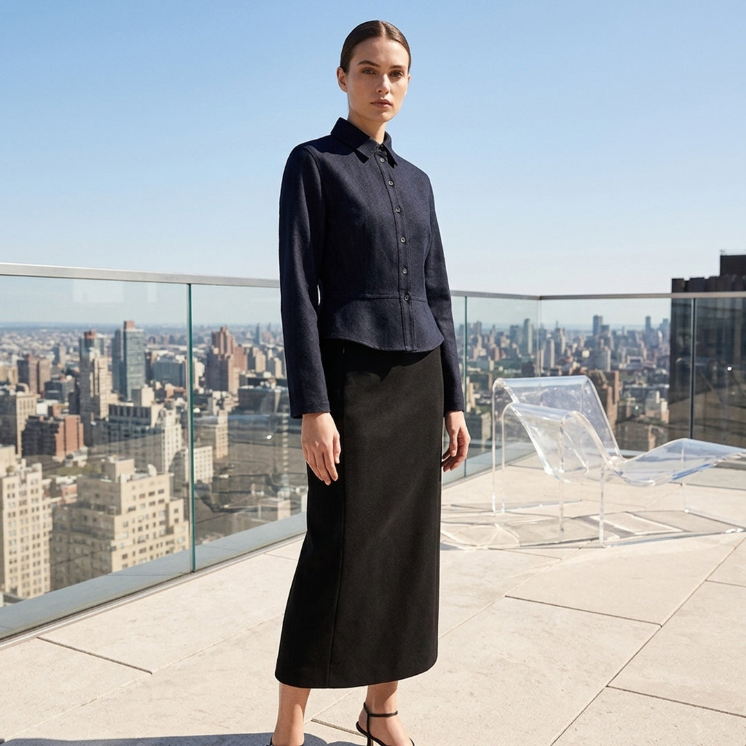 Alaïa Basque Shirt Wool Denim jacket in dark indigo, featuring a point collar, concealed button-front placket, structured basque waist seam, tonal contrast stitching, and a cropped curved hem — front view on white background - lifestyle