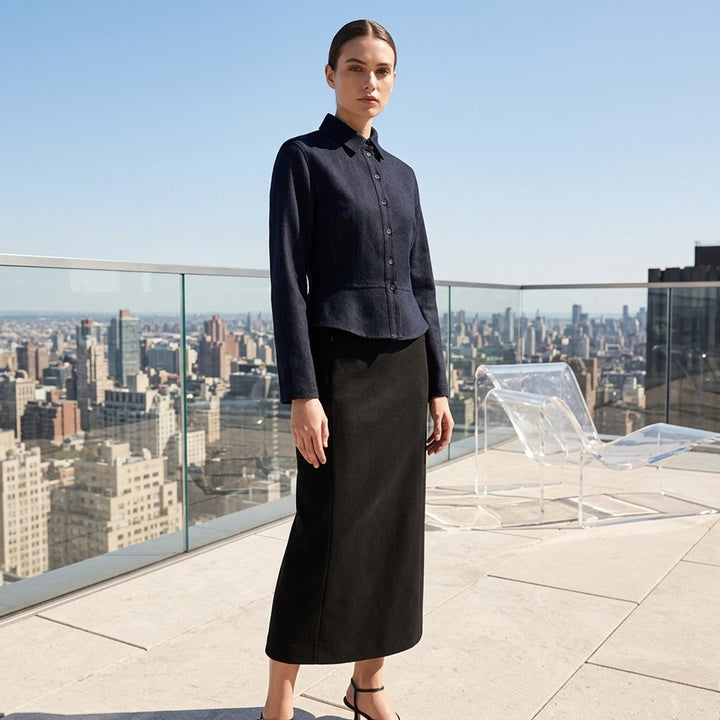 Alaïa Basque Shirt Wool Denim jacket in dark indigo, featuring a point collar, concealed button-front placket, structured basque waist seam, tonal contrast stitching, and a cropped curved hem — front view on white background - lifestyle