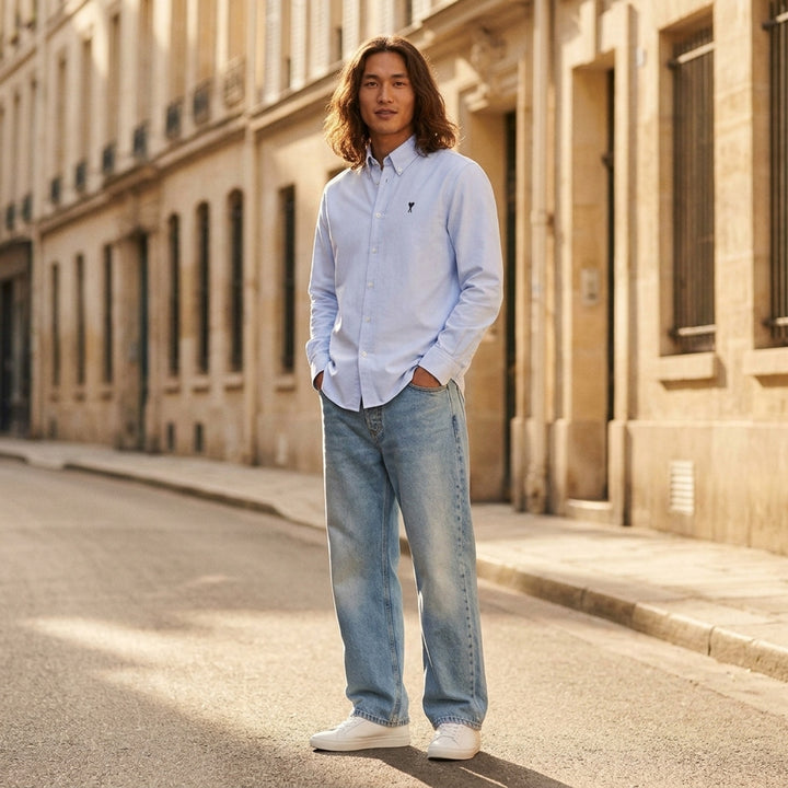 AMI Large Fit Jeans in light blue stonewash denim, featuring a relaxed wide-leg silhouette, five-pocket construction, and contrast copper topstitching - lifestyle