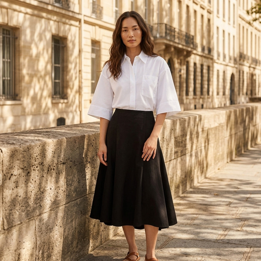 AMI black midi godet skirt with flared paneled silhouette and asymmetric hem, shown from the front - lifestyle