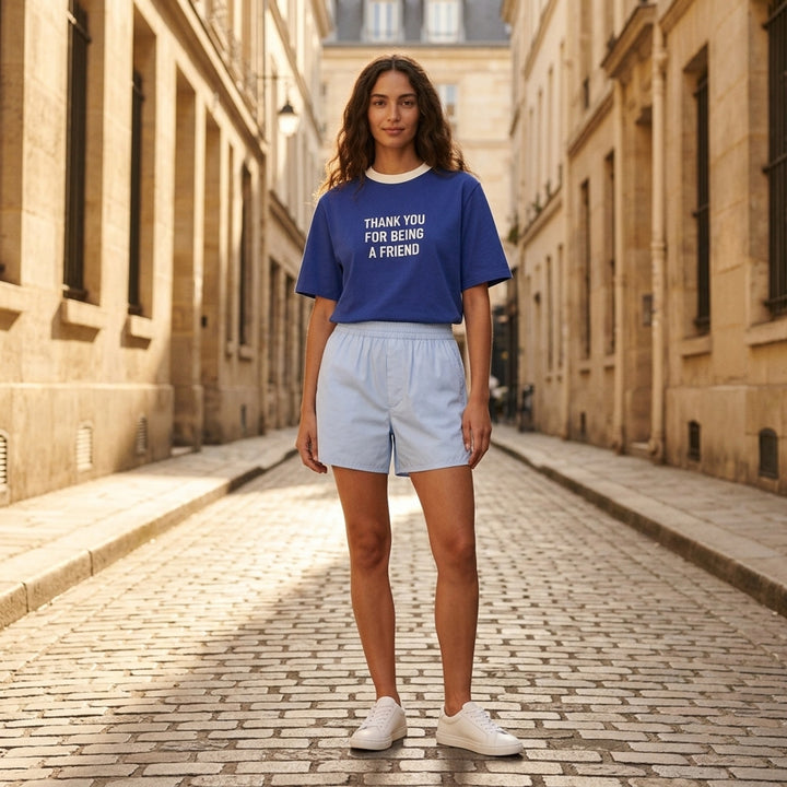 AMI royal blue cotton graphic T-shirt with 'Thank You For Being A Friend' slogan print in cream lettering, featuring a contrast cream ribbed crew neckline and AMI de Cœur logo at the hem - lifestyle