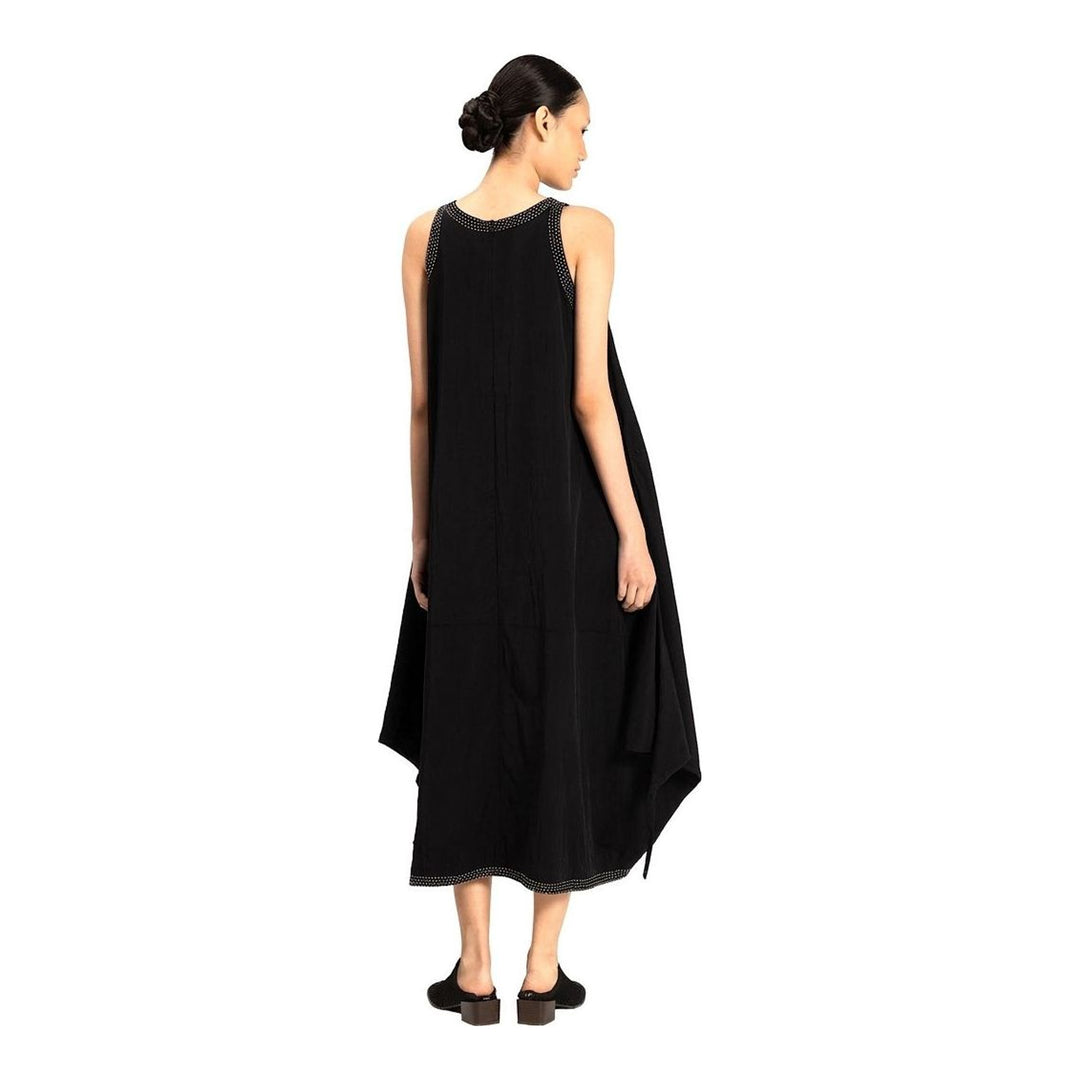 Model wearing an Anaabu black sleeveless midi dress with a voluminous A-line silhouette, asymmetric handkerchief hemline, and fine metallic stud trim at the neckline and hem - packshot