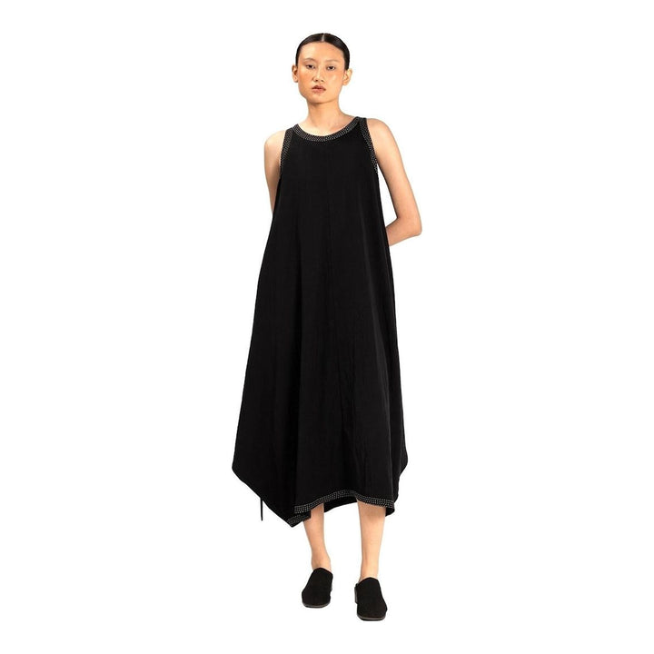 Model wearing an Anaabu black sleeveless midi dress with a voluminous A-line silhouette, asymmetric handkerchief hemline, and fine metallic stud trim at the neckline and hem - packshot