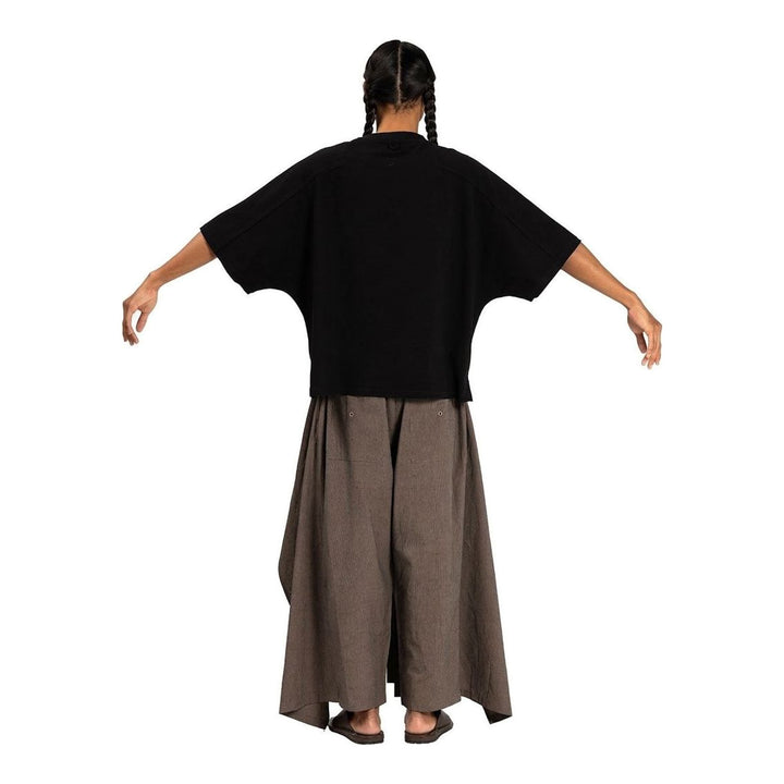 Model wearing the Anaabu Boxy Short Sleeve Tee in black — an oversized, dropped-shoulder silhouette styled over a taupe wide-leg trouser skirt - packshot