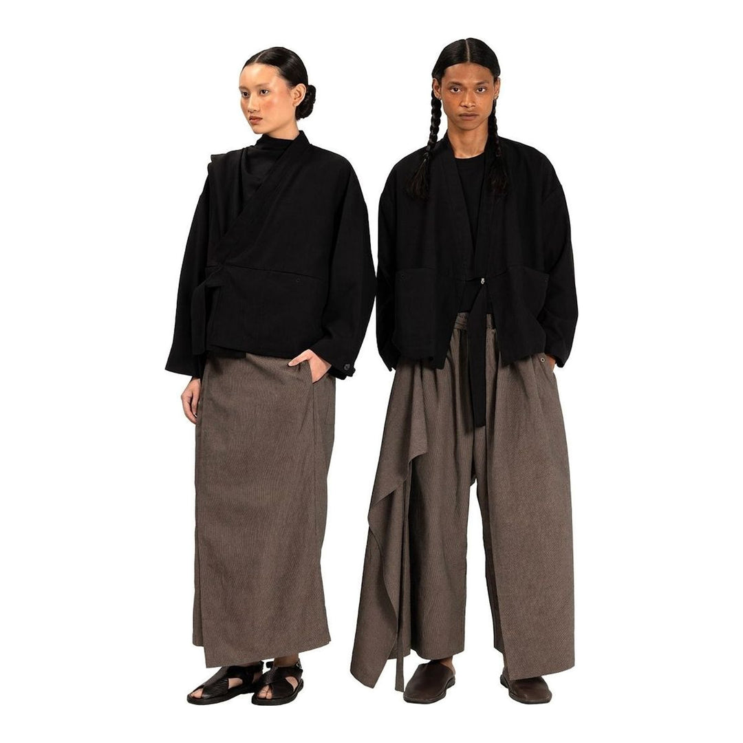 Model wearing Anaabu The Skants — black wide-leg cropped pants with large draped overlay panels featuring pinstripe and dot print, paired with a black square-neck crop top and leather sandals - packshot