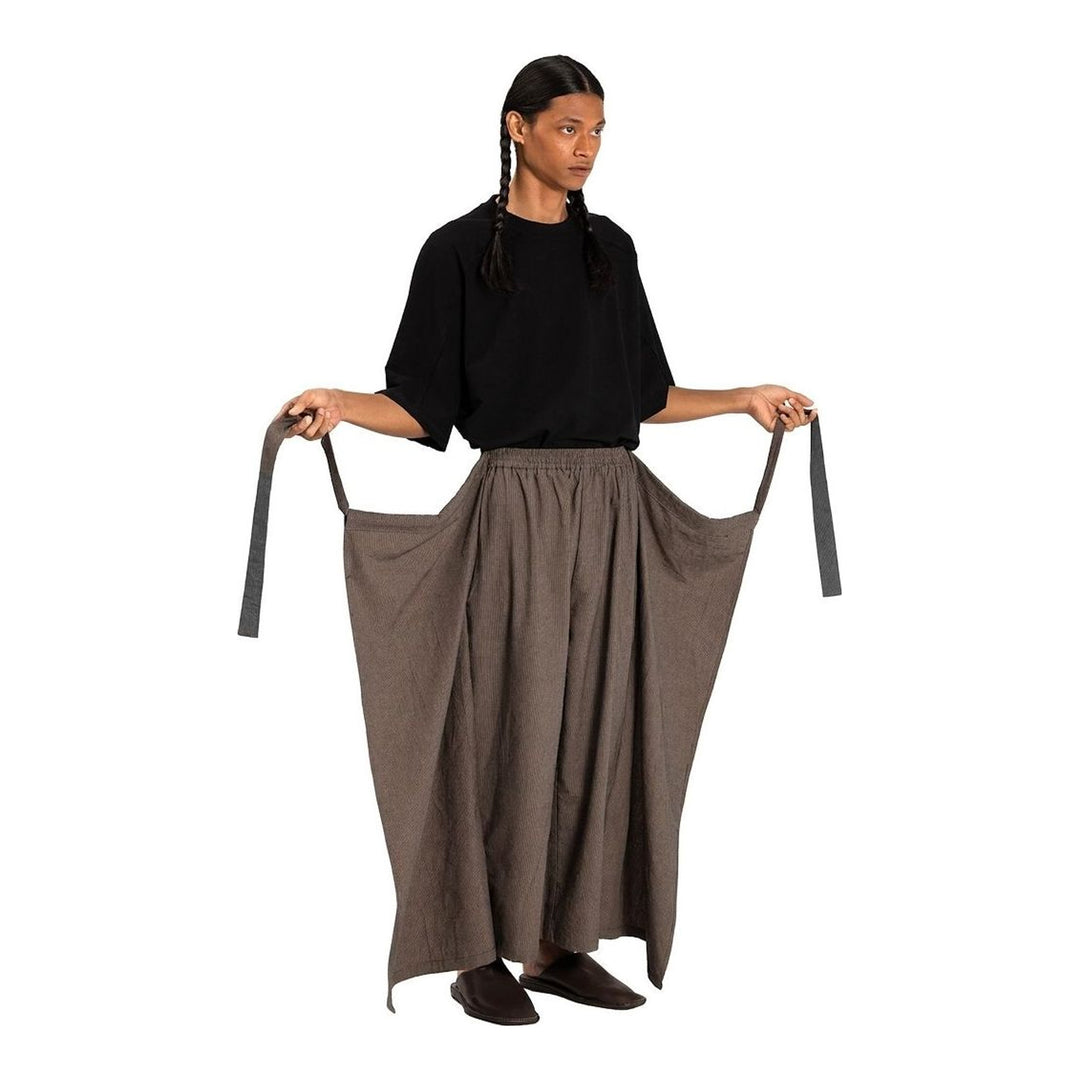 Model wearing Anaabu The Skants — black wide-leg cropped pants with large draped overlay panels featuring pinstripe and dot print, paired with a black square-neck crop top and leather sandals - packshot
