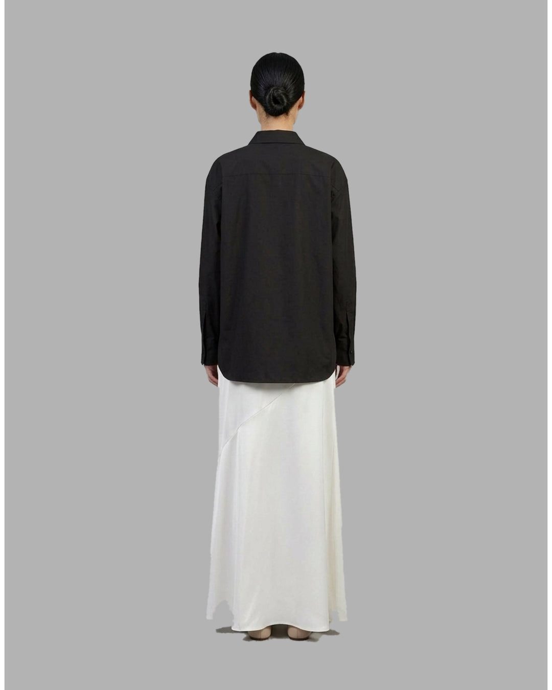 Ivory matte acetate-mix maxi skirt with a diagonal seam and flared hem, shown from the front - back