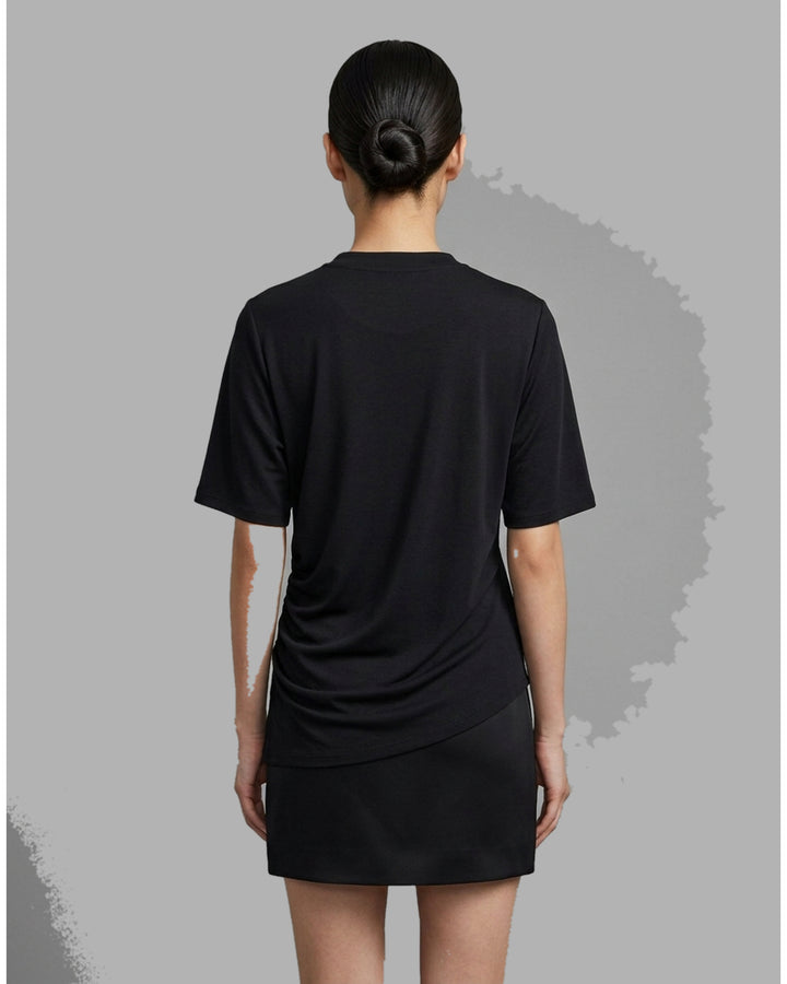 Black short-sleeve crew neck jersey tee with gathered side draping and an asymmetric hem, shown flat against a white background - back