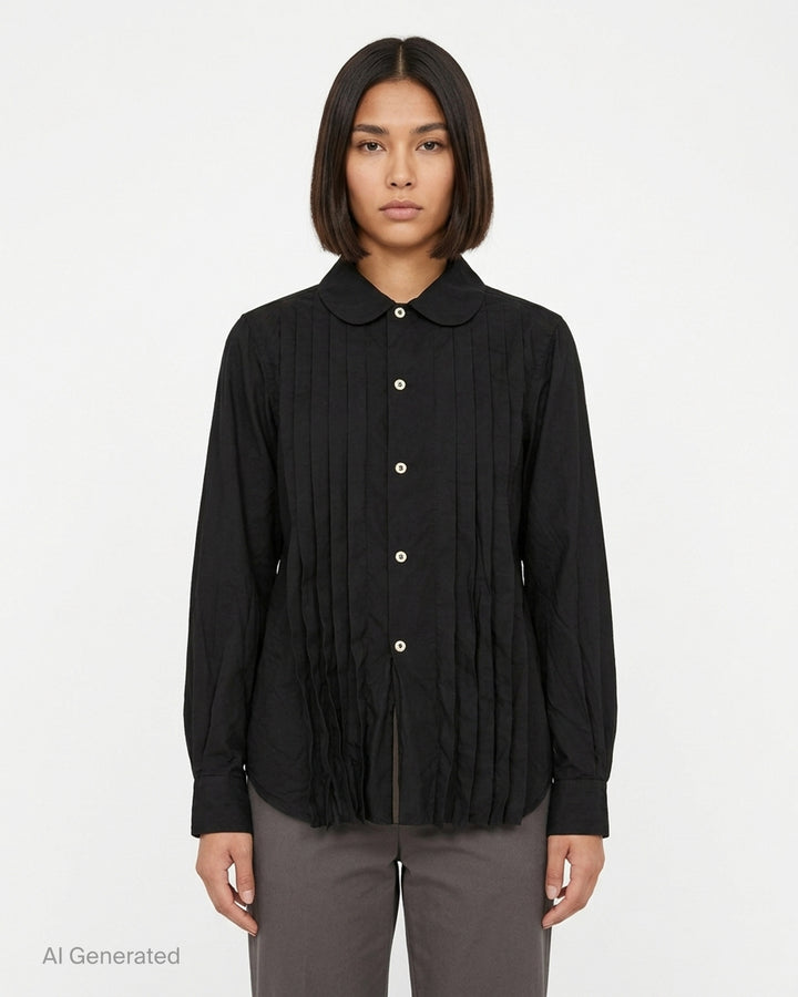 Black pleated button-down shirt with rounded collar, pale buttons and frayed pleated hem by Comme des Garçons Comme des Garçons - front