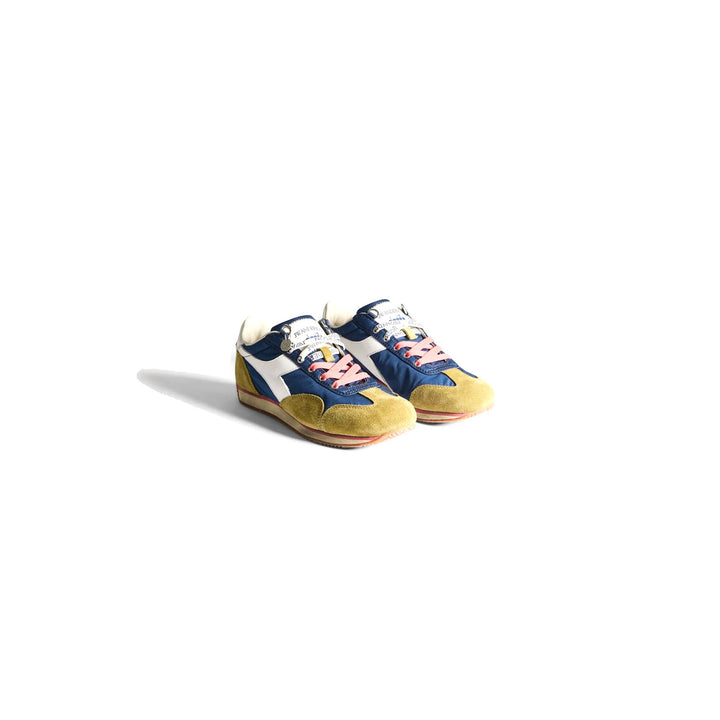 Diadora x JW Anderson retro nylon sneaker in blue with khaki suede overlays, coral laces, and a white Diadora logo stripe, set against a white background - packshot