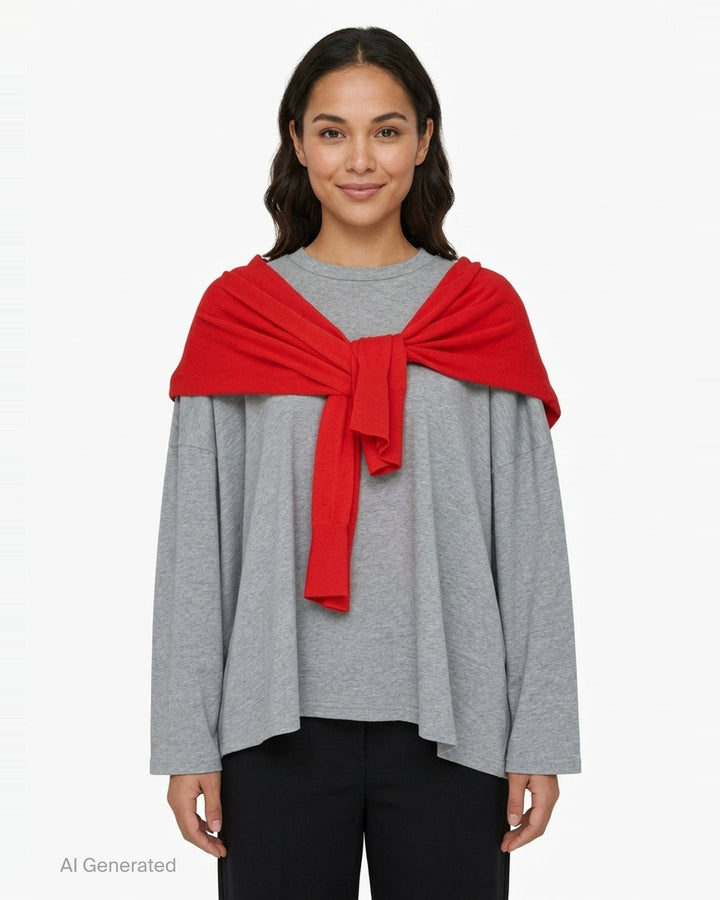 Enfold oversized grey marl long sleeve tee with attached red knitted cape draped over both shoulders and tied in a knot at the chest, styled flat on a white background - front