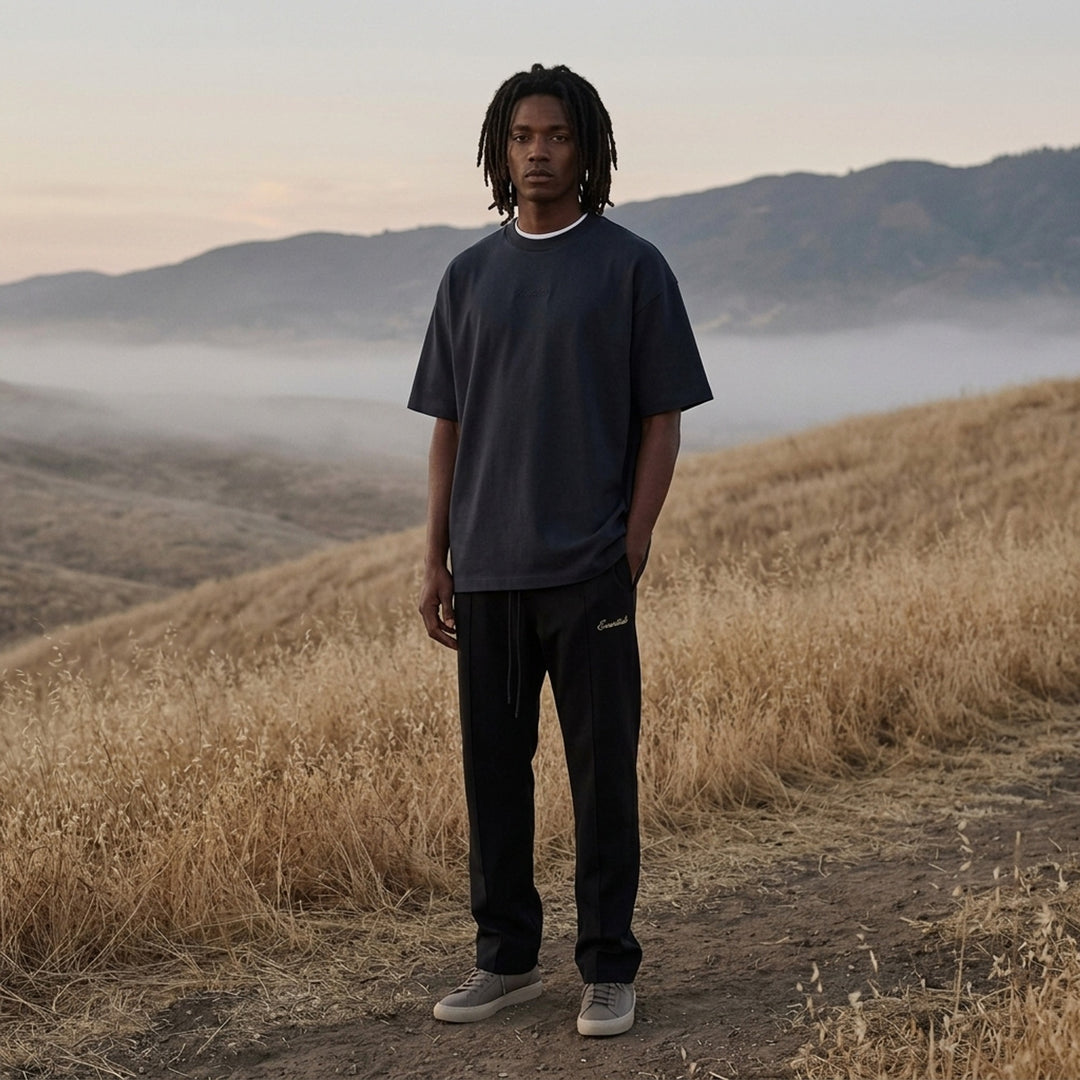 Fear of God ESSENTIALS Classic Double Layer Tee in black with white undertee at the neckline and hem and tonal embroidered logo at the chest - lifestyle