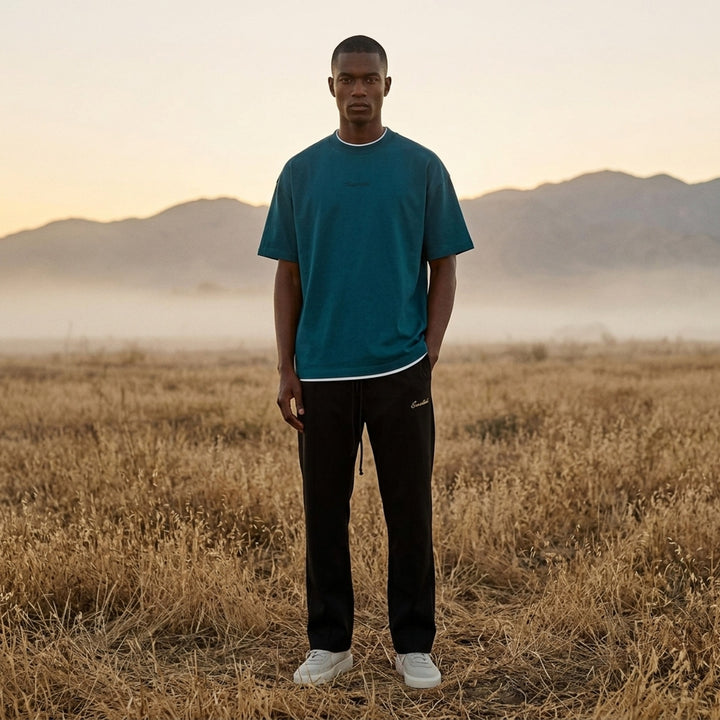 Fear of God ESSENTIALS Classic Double Layer Tee in black with white undertee at the neckline and hem and tonal embroidered logo at the chest - lifestyle