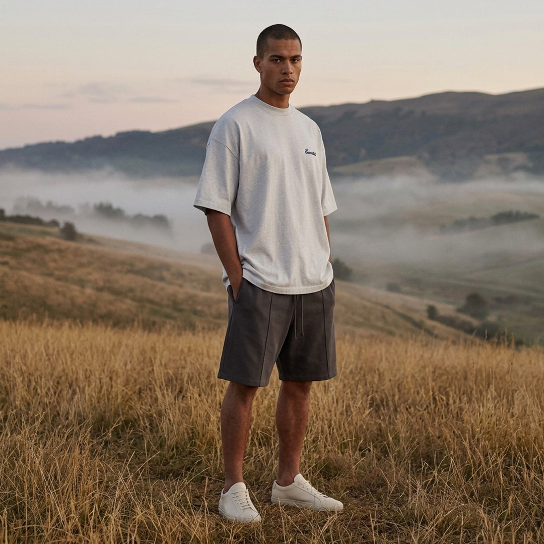 Fear of God Essentials Signature Short Sleeve Tee in washed grey, featuring an oversized boxy silhouette, ribbed crewneck, and tonal script logo at the chest - lifestyle