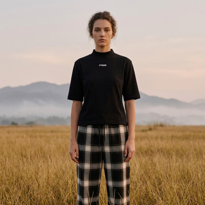 Fear of God ESSENTIALS women's slim mockneck tee in black with ribbed high neck, short sleeves and small white logo at the centre chest - lifestyle