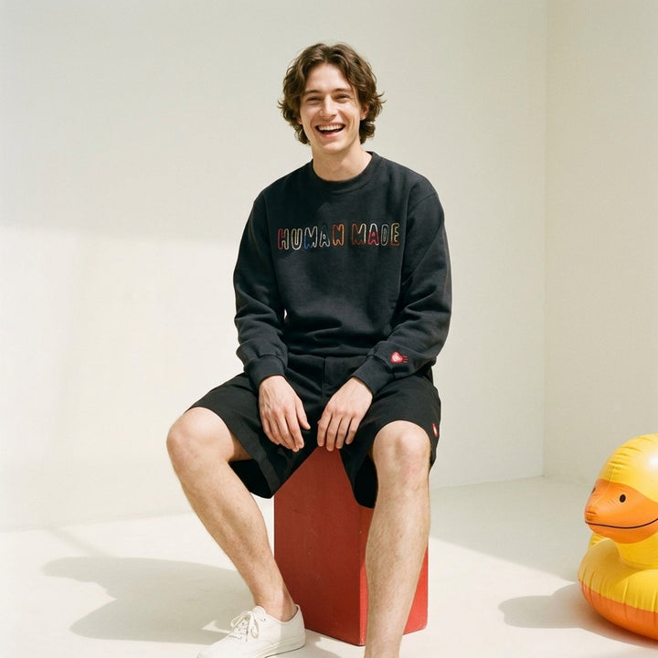 Human Made Embroidered Crewneck Sweatshirt in washed black with multicolour chain-stitch logo lettering across the chest and a heart logo patch on the cuff - lifestyle