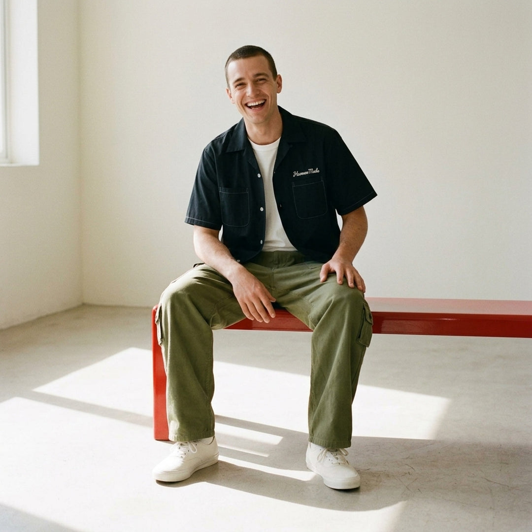 Human Made multi-pocket cargo pants in dark espresso brown, featuring a wide-leg silhouette, buckle waistband, and multiple buttoned utility cargo pockets - lifestyle