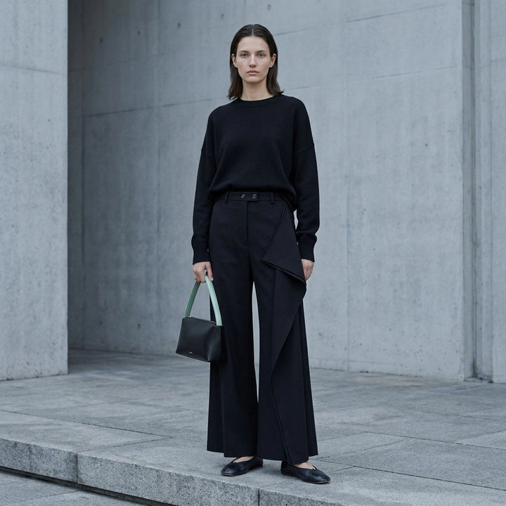 Jil Sander black wide-leg trousers with a cascading draped panel and button-fastened waistband, shown from the front - lifestyle