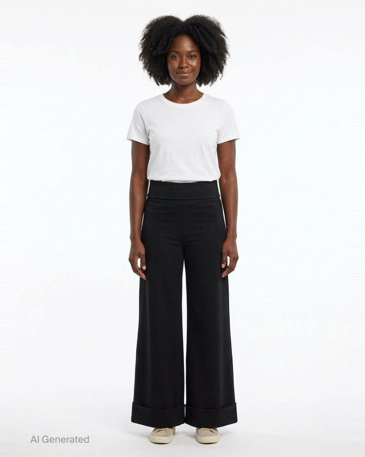 Junya Watanabe straight-leg minimal pants in black, featuring a fold-over waistband, wide silhouette, centre-front seam, and deep turned cuff at the hem, displayed flat on a white background - front