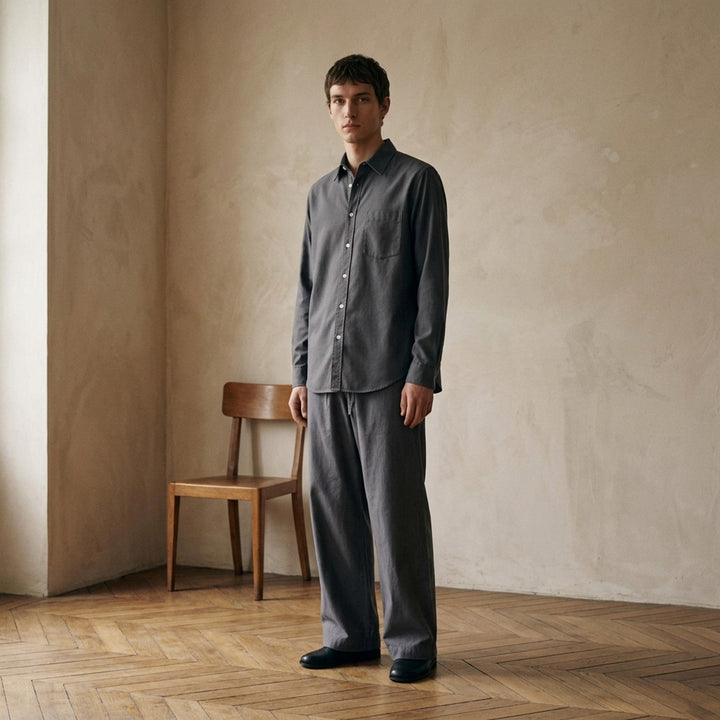 Lemaire Regular Long Sleeve Washed Cotton Shirt in slate grey, displayed flat against a white background, featuring a classic collar, white buttons, and a chest patch pocket - lifestyle
