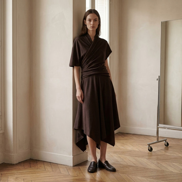 Lemaire twisted asymmetric draped dress in wool viscose jersey with gathered waist and handkerchief hem, shown from the front - lifestyle