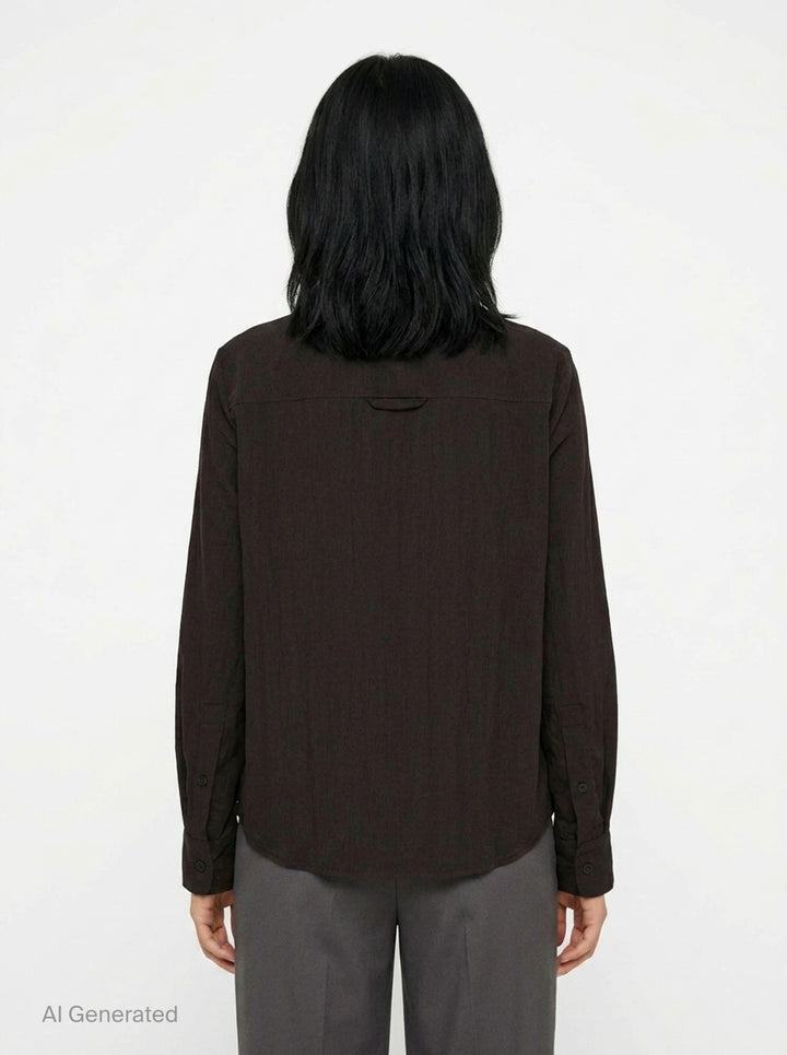 Melitta Baumeister Circle Shirt in black, featuring an asymmetric curved button placket, point collar, chest patch pocket, and structured long sleeves with wide cuffs - back