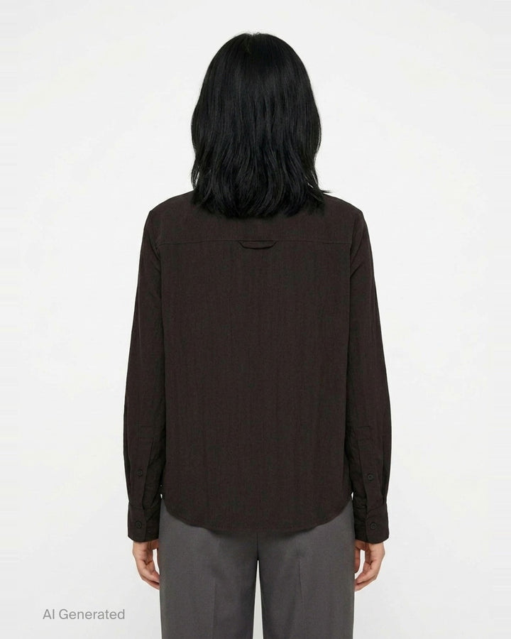 Melitta Baumeister Circle Shirt in black, featuring an asymmetric curved button placket, point collar, chest patch pocket, and structured long sleeves with wide cuffs - back