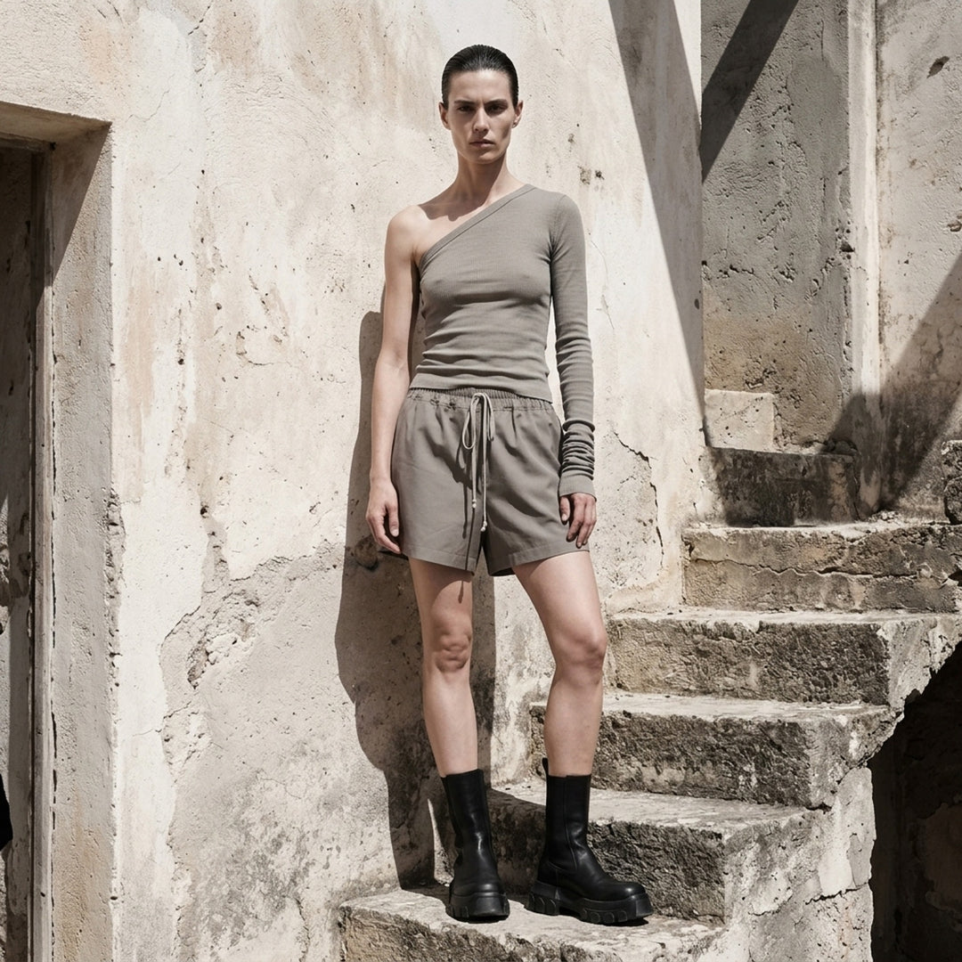 Rick Owens Ziggy black one-shoulder ribbed knit top with a single long ruched sleeve and cropped hem, photographed on a white background - lifestyle