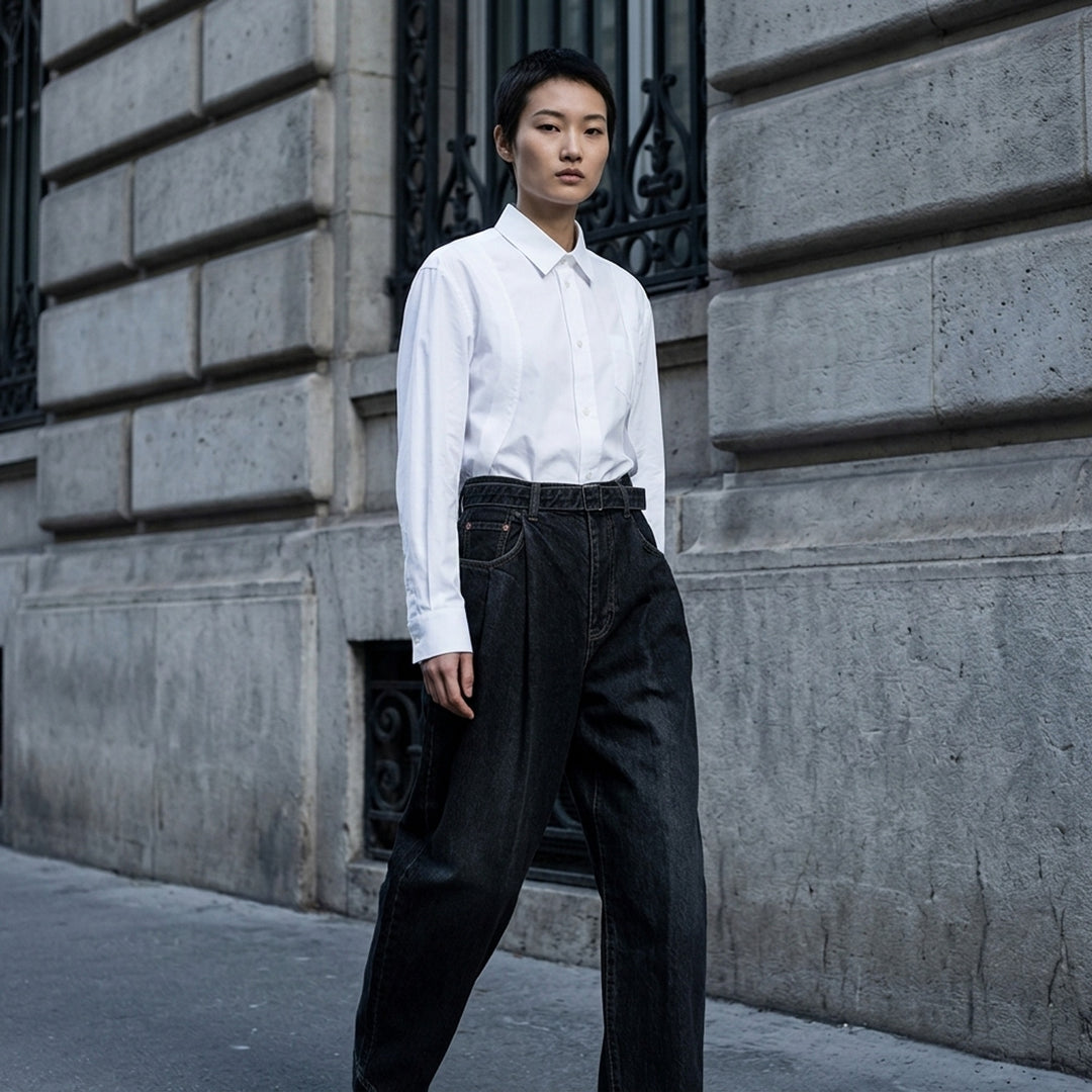 sacai belted wide-leg barrel jeans in washed black denim with deep front pleats, contrast stitching, and tapered hem, photographed flat on white background - lifestyle