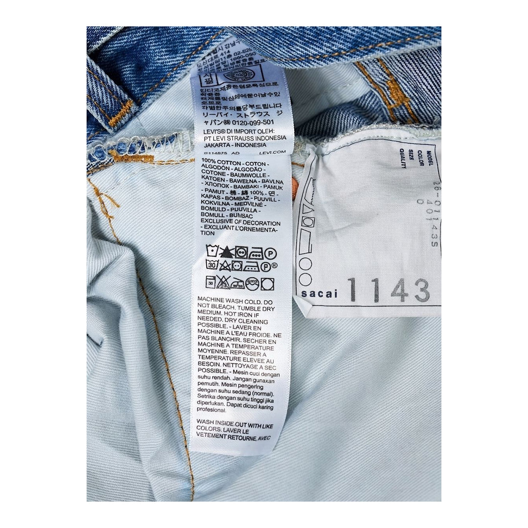 sacai x Levi's mid-blue washed flare jeans with an integrated black woven belt, shown from the front - packshot