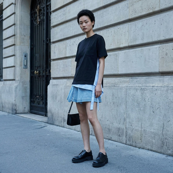 sacai Poplin x Cotton Jersey T-Shirt in black with asymmetric blue pinstripe poplin panel draped at the side hem, crew neck, short sleeves, and chest pocket - lifestyle