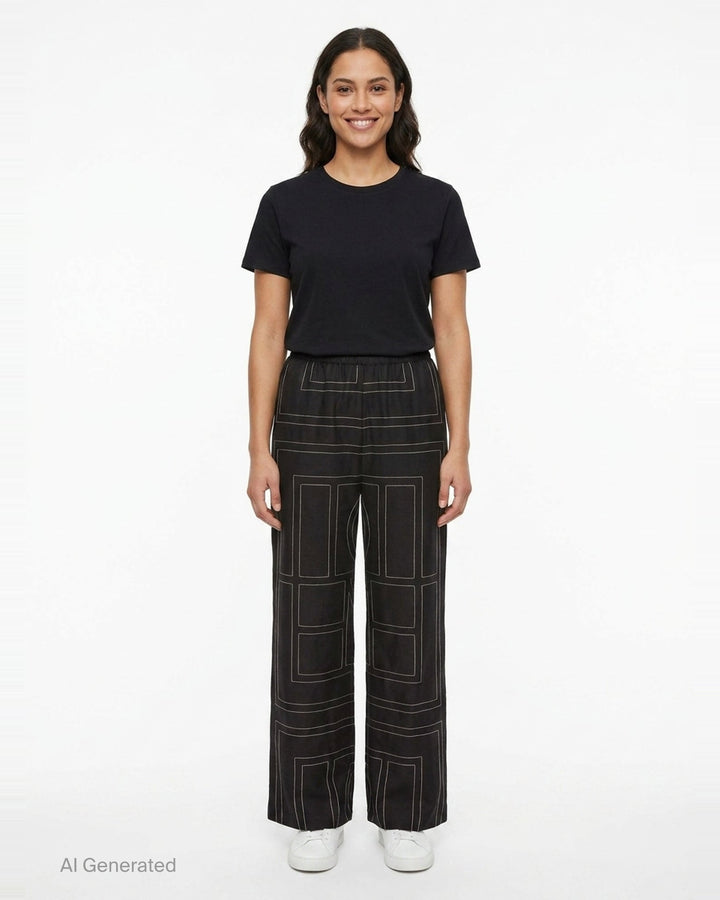 Toteme Monogram Silk Pyjama Pants in black with all-over contrast white stitched geometric panel print and elasticated waistband, wide-leg silhouette, flat lay view - front