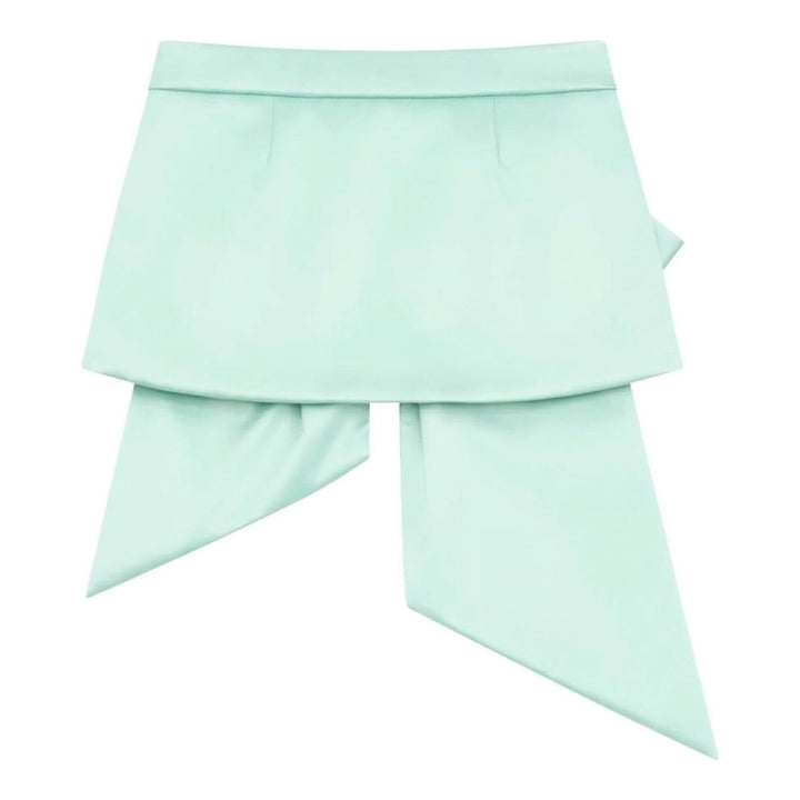 Vaquera mint green satin mini skirt with an oversized pleated bow overlay and long trailing tails, shown flat against a white background - packshot